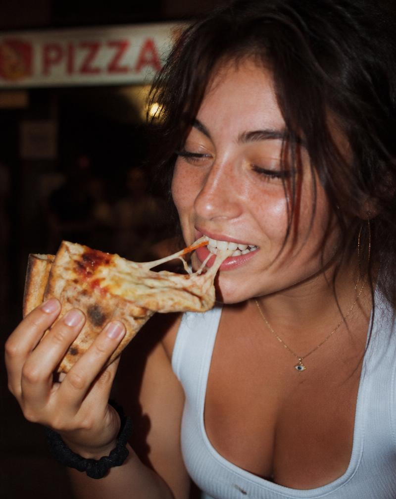 Close-up of someone biting into a slice